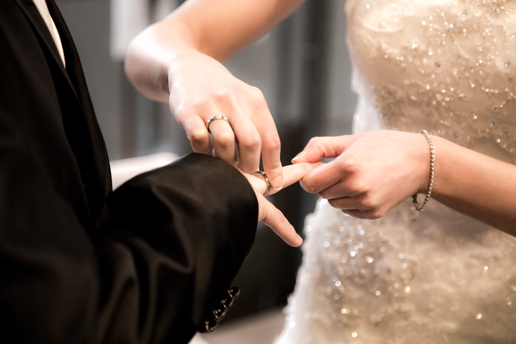Die Braut steckt den Ehering auf den Ringfinger des Bräutigams auf.
