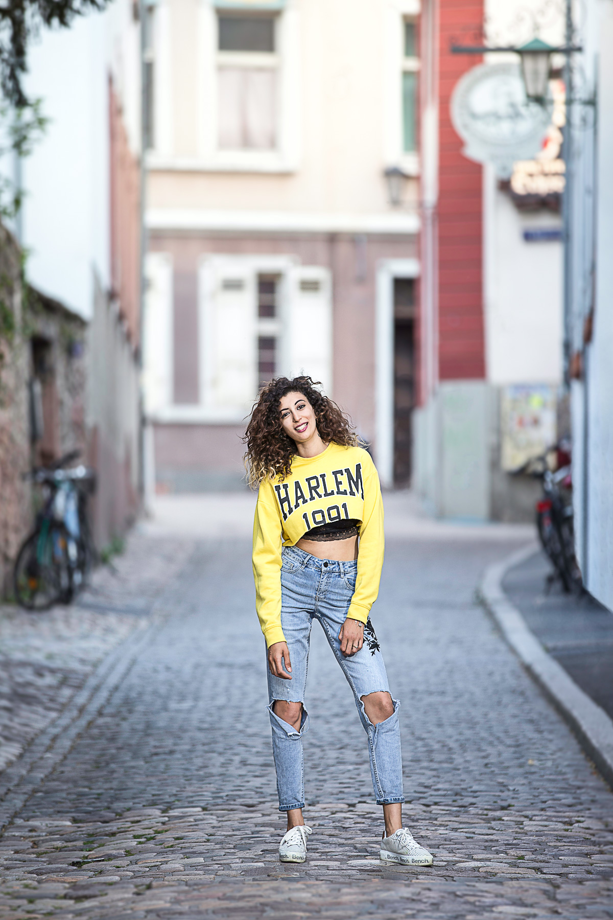 Outdoorportraitfoto einer trendigen, jungen Singlefrau in der Altstadt von Heidelberg