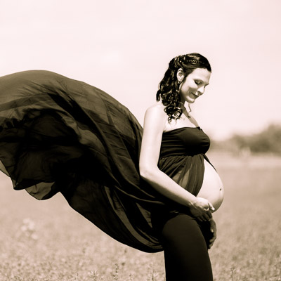 Schwangere Frau mit schönem Schleierkleid im Feld