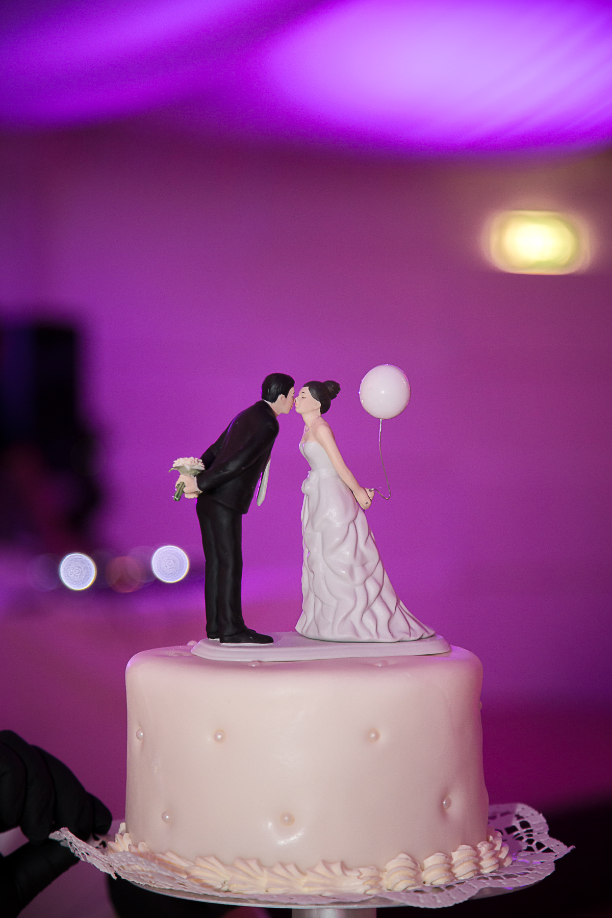 Eine Miniaturfigur in Form eines küssenden Brautpaars als Krönung der Hochzeitstorte