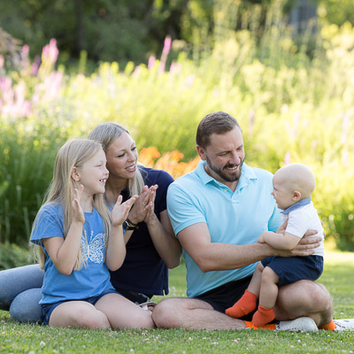 Familie mit zwei Kindern auf der Parkwiese. Fotograf Fotoshooting.