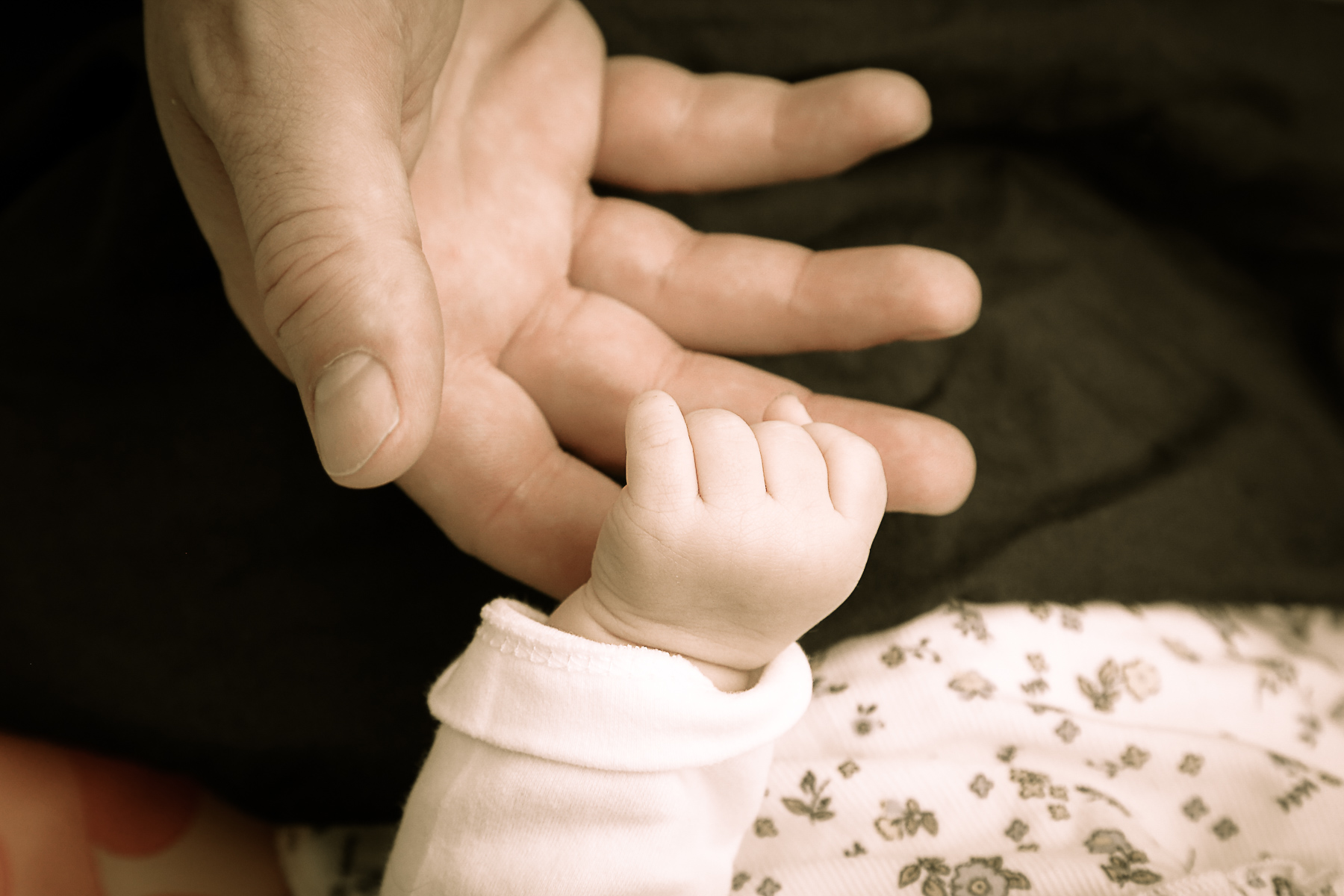 Nahaufnahme der Hand eines neugeborenen Kleinkindes und der Hand des Vaters