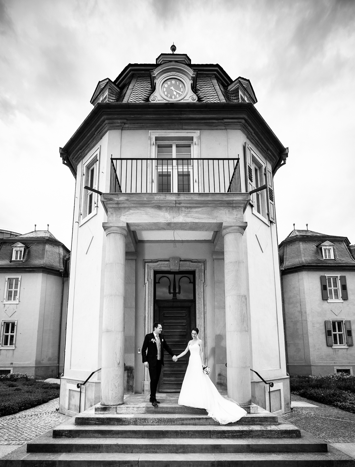 Kontakt zum Fotograf. Ein Brautpaar läuft die Treppe einer Kapelle hinunter.